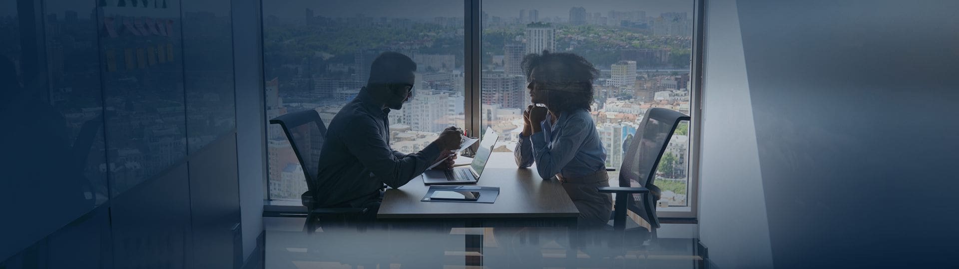 Business colleagues meeting by city window.